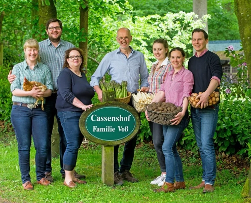 Eine fröhliche Mehrgenerationenfamilie steht stolz auf dem Cassenshof und hält frische Produkte und ein Bio-Festtagsgans in den Händen, was ihr Engagement für nachhaltige Landwirtschaft und lokale Landwirtschaft symbolisiert. - Ihr Landhaus Scherrer aus Hamburg