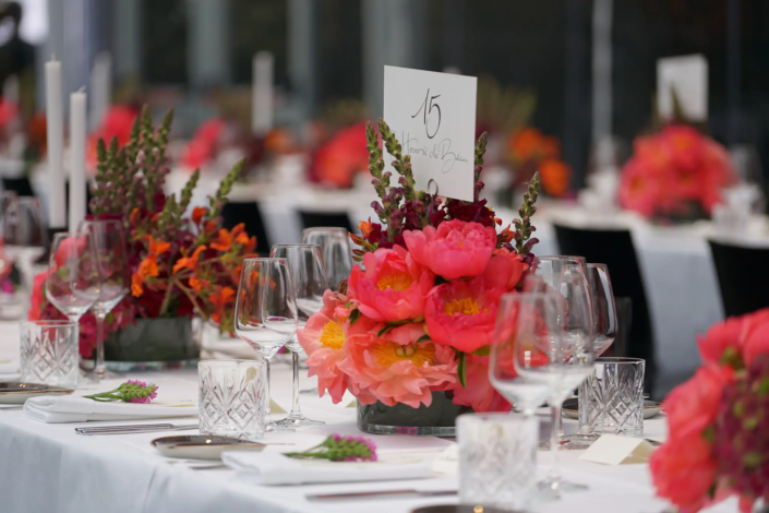 Ein elegant gedeckter Banketttisch mit farbenfrohen Blumendekorationen, strahlend weißer Tischwäsche und edlem Glasgeschirr, bereit für ein anspruchsvolles Event, gekennzeichnet durch die Tischnummern. - Ihr Landhaus Scherrer aus Hamburg