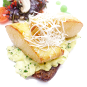 Gegrilltes Fischfilet mit geriebenem Käse, serviert auf einem Bett aus cremiger Kräutersauce mit Gartensalat und Kirschtomaten als Beilage. - Ihr Landhaus Scherrer aus Hamburg Gegrilltes Fischfilet mit geriebenem Käse, serviert auf einem Bett aus cremiger Kräutersauce mit Gartensalat und Kirschtomaten als Beilage. - Ihr Landhaus Scherrer aus Hamburg