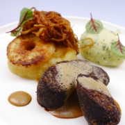 Gebackene Grützwurst, auch als Himmel und Erde bekannt, mit gebratenem Apfelring, Apfelkren und Röstzwiebeln garniert, dazu frisch gerührtes Kartoffelpürree als Beilage