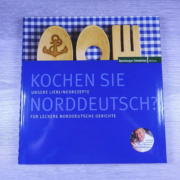 Ein Kochbuch mit dem Titel "Kochen Sie norddeutsch?" in weißer Schrift auf blauem Einband, mit Untertitel und einem Bild des Küchenchefs Heinz O. Wehmann, der auf einem blauen - Ihr Landhaus Scherrer aus Hamburg