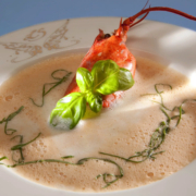 Der handwerkliche Klassiker - Hummer-Suppe in höchster Qualität. Die Suppe wird aus Hummer-Karkassen hergestellt und in vielen handwerklichen Schritten zur höchsten Qualität abgeschmeckt. Zum Servieren wird die Suppe kurzt aufgeschäumt und mit frischen Kräutern oder Kräuteröl dekoriert. - Ihr Landhaus Scherrer aus Hamburg