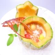 Die geeiste Hummer-Melonen-Suppe hat sich über die Jahre zum Klassiker in den Sommer-Monaten auf der Terrasse entwickelt. Die Melone wird handwerklich aufgeschnitten und ausgehöhlt, die Suppe kalt eingefüllt und mit bunten Melonenkugeln und Hummer dekoriert.